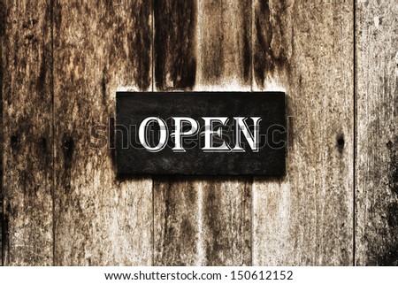 Open sign pinned onto a painted wooden door
