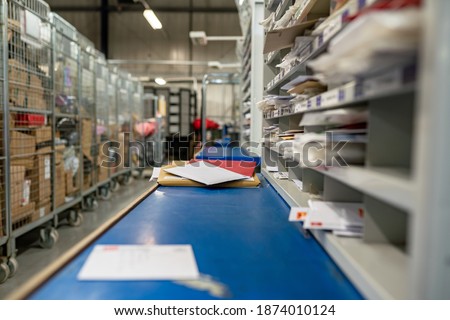 Postal service, post office inside. Letters on a sorting frame, table and shelves in a mail delivery sorting centre. 