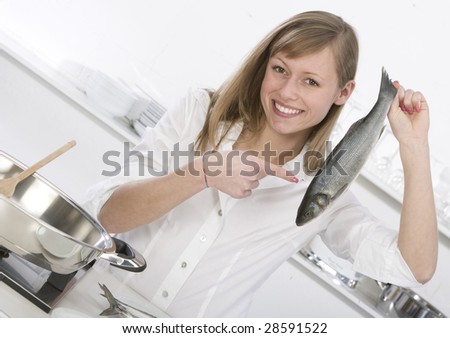 young woman in the kitchen with fish in hand
