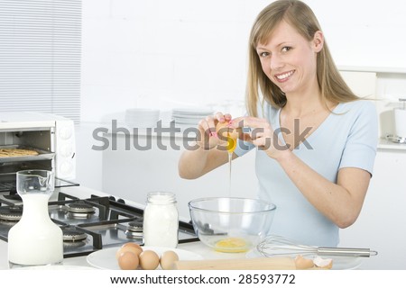 Beautiful woman in kitchen is making a cake