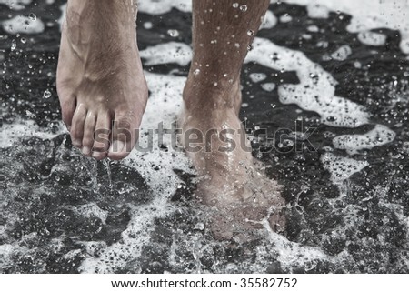 man feet in the shower under the streams of water