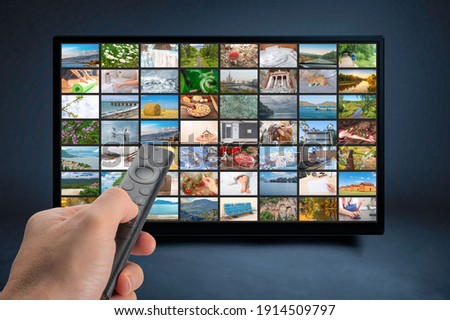 Male hand holding TV remote control. Multimedia streaming concept. VoD content provider concept. Television streaming video concept. Video service with internet streaming multimedia shows, series.