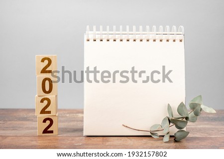 2022 time for a new start. Plan words and 2022 cubes wooden table background. New Year. plans for 2022, space for your text on notepad, mockup calendar