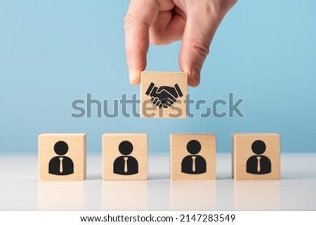 business contract. Hand putting hand shaking which print screen on wooden cube block in front of human icon for business deal and agreement concept. Teamwork process of partner and best relationship. Foto stock © 