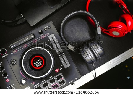 Professional concert DJ red headphones top view.High quality mixing controller for disc jockey in night club.Pro audio equipment on stage in nightclub.Play music & listen tracks with hifi headset. 