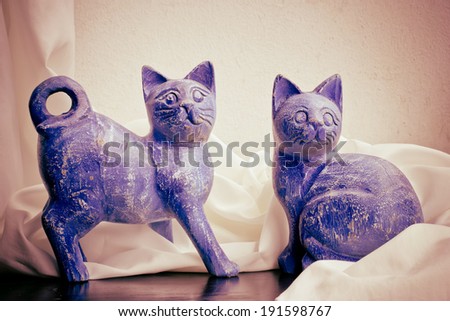 A handmade wooden sculpture of cats painted by hand. Still life.
