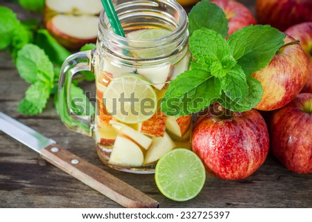 Mug delicious refreshing drink of apple fruits with mint on wooden, infused water