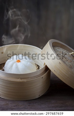 Chinese steamed bun in bamboo ware on wooden table