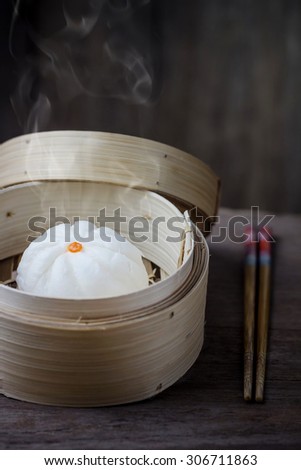 Chinese steamed bun in bamboo ware on wooden table