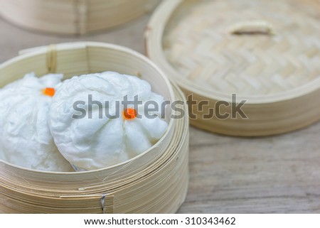 Chinese steamed bun  in bamboo ware on wooden table