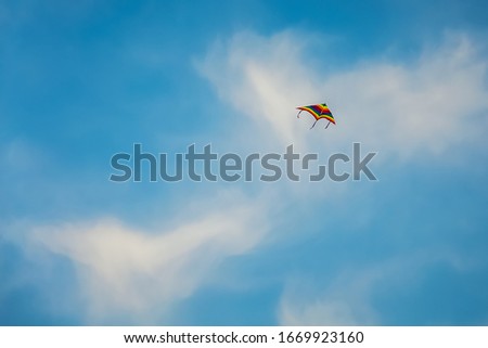 Single kite is flying on blue sky with clouds background in Fanateer beach - Jubail Saudi Arabia.