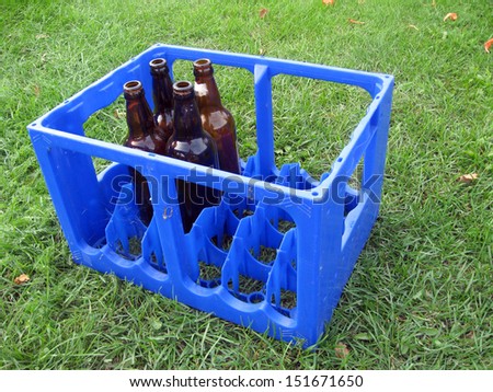 Empty beer bottles in the blue plastic box