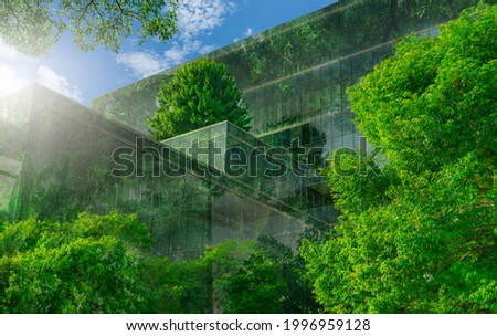 Selective focus on tree and eco friendly building with vertical garden in modern city. Green tree forest on sustainable glass building. Office building with green environment. Go green concept.