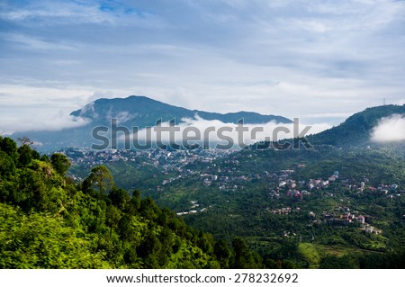 Clouds rolling between the hills of himachal pradesh in India. The small hill villages are visible among the green hills
