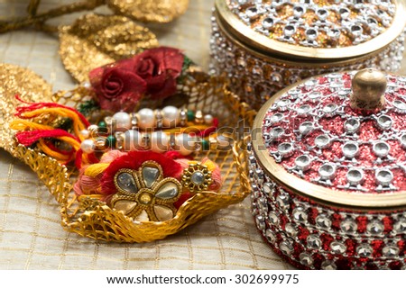 Rakhi thread in a golden holder along with a beautiful box decorated with jewels