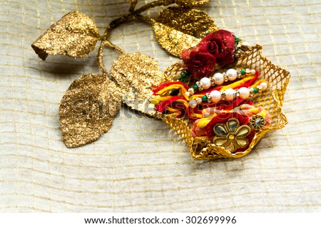 Rakhi threads put on a decorated stand with golden leaves to decorate it