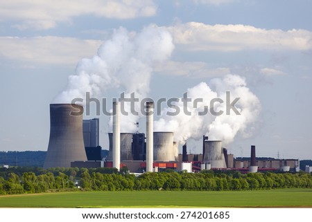 A coal-fired power station in the distance in agricultural landscape. The power station Niederaussem has the second highest cooling tower in the world with a height of 200m.