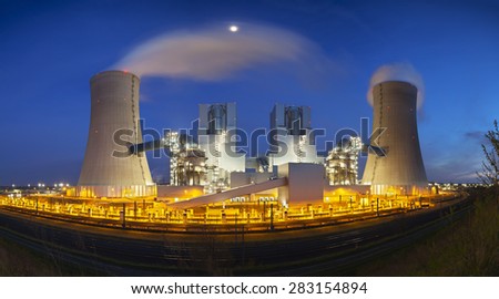 A modern brown coal power station with night blue evening sky. Panoramic wide angle shot.