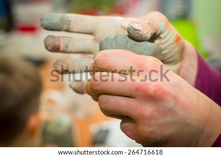 Hands stained with clay and paint. Hands painter and sculptor. Children\'s creativity and a hobby for adults. Modeling. Hands and fingers stained with paint.