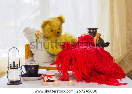 Bear - a toy is in the crib, and measures the temperature of the thermometer near the Bears candles, jar of jam, a samovar, a cup of tea. Bear sheltered warm red knitted shawl.