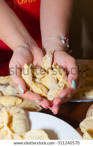 Women\'s hands holding handmade dumplings, dumplings modeling. dumplings