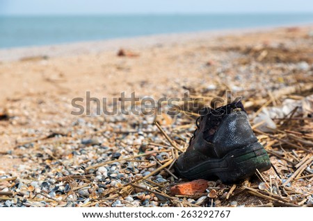Pollution: shoes, garbages, plastic, and wastes on the beach after winter storms. Azov sea. Dolzhanskaya Spit