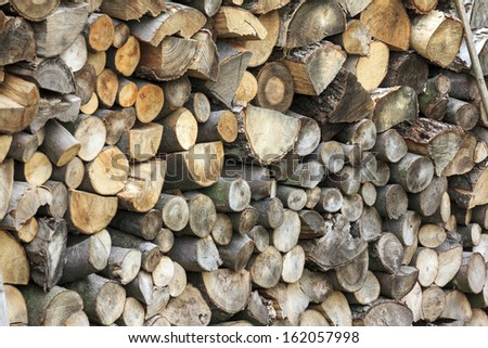 Logs of wood of different shapes, sizes and kinds piled together