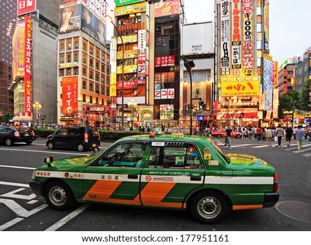 Tokyo, Japan - June 26, 2010: Characteristic green Tokyo taxi with crowds of people and neons in background in Shinjuku district on 26 June 2010 in Tokyo, Japan.
