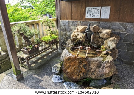 Kanazawa, Japan - June 21, 2010: Purification ladles and bonsai trees in front of a house in  Kanazawa old town on June 21, 2010.