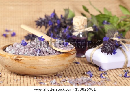 Spa background with sea salt, flowers, soap and essential oil.