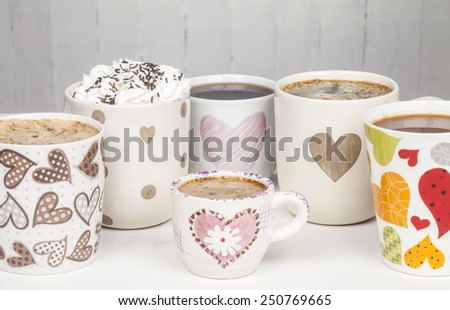Lots of coffee in different cups with hearts. Copy space.