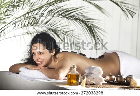 Spa Stone Massage. Beautiful Woman Getting Spa Hot Stones Massage in Spa Salon.