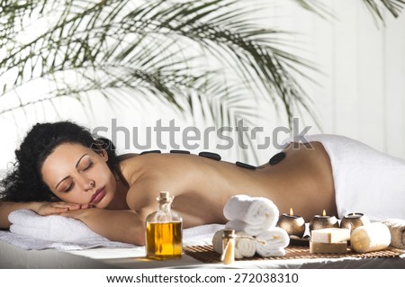 Spa Stone Massage. Beautiful Woman Getting Spa Hot Stones Massage in Spa Salon.
