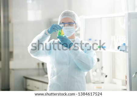 Similar – Image, Stock Photo Serious chemist examining liquid in flask in lab