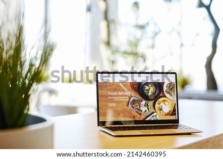 Background image of opened laptop with Food delivery service website set on table in cafe, copy space Stockfoto © 
