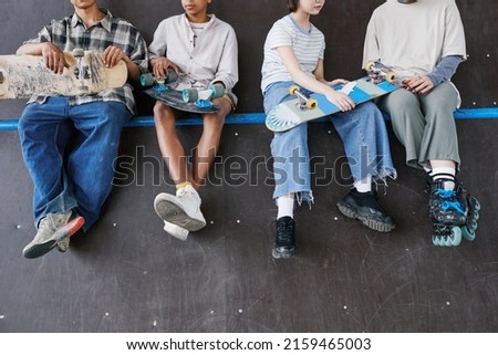 Diverse group of teenagers sitting on ramp in skateboarding park low section of feet dangling, copy space Foto d'archivio © 