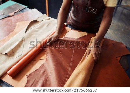 Top view close up of black female artisan working with genuine leather in workshop, copy space 商業照片 © 