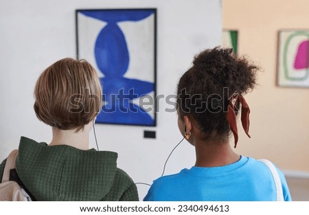 Similar – Image, Stock Photo Schoolgirls looking for audio books in school library. Students choosing books. Elementary education. Doing homework. Back to school