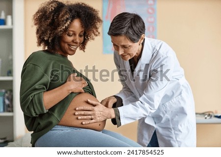 Similar – Image, Stock Photo Smiling pregnant woman touching belly on floor at home