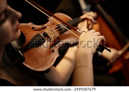 Foto Bild Nahaufnahme einer Violine mit Bogen. Braune Orchestergeige. Finger auf der Tastatur der Violine.