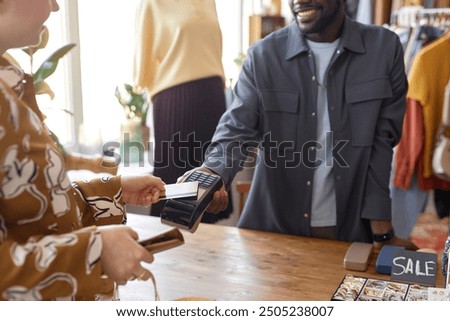 Similar – Image, Stock Photo Focused female cashier in face mask working with cash till