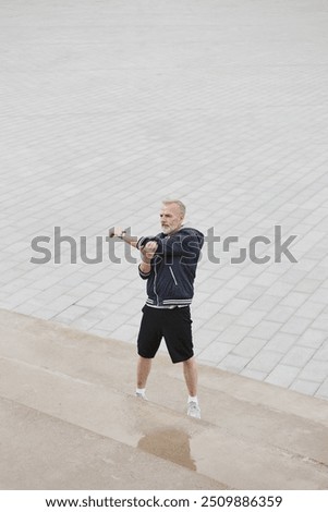 Foto Bild Ernster Sportler streckt die Arme auf der Straße