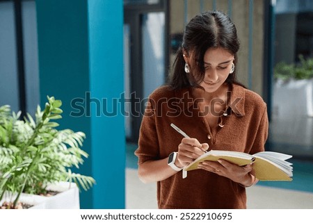 Similar – Image, Stock Photo Female freelancer taking notes in notebook