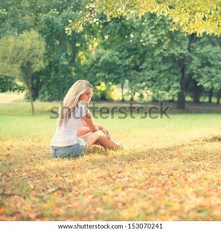long-haired sad girl relaxing in the park