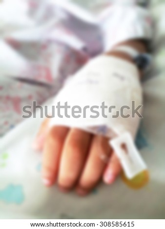 children patient in hospital with saline intravenous , blur and out of focus.