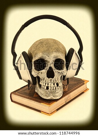 Scary, Haunted, Horror Audiobook concept with human skeleton wearing audio headset sitting on book.