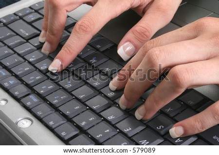 Close-up of sexy manicured hands on laptop keyboard.