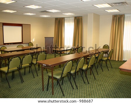Small meeting room with table, chairs, presentation board, podium.