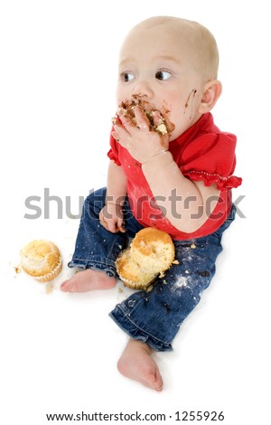 Baby eating cake, making mess on face.