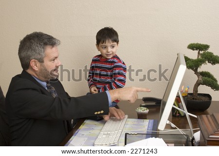 Office working talking to small child sitting on desk.